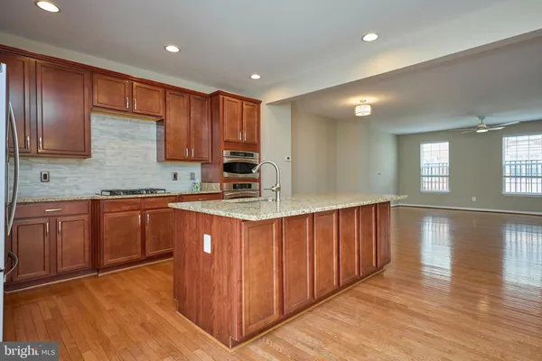 a kitchen with stainless steel appliances granite countertop a refrigerator a sink and wooden cabinets