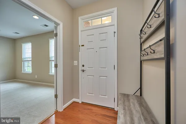 a view of a hallway with wooden floor and closet area