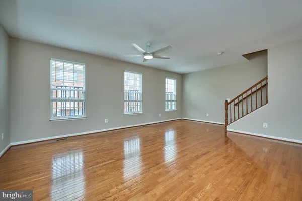 a view of an empty room with window and wooden floor