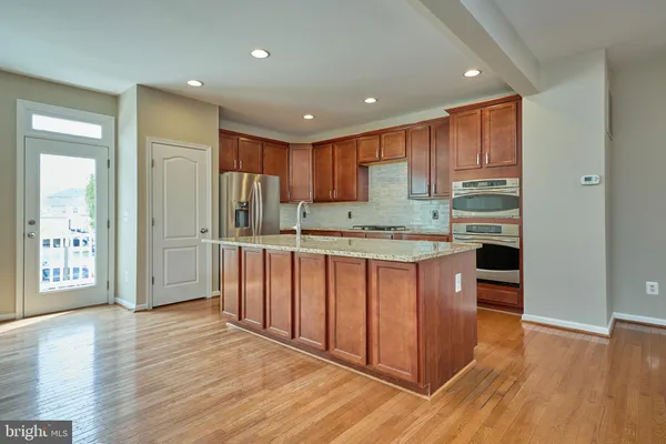 a kitchen with stainless steel appliances granite countertop a refrigerator and a stove top oven