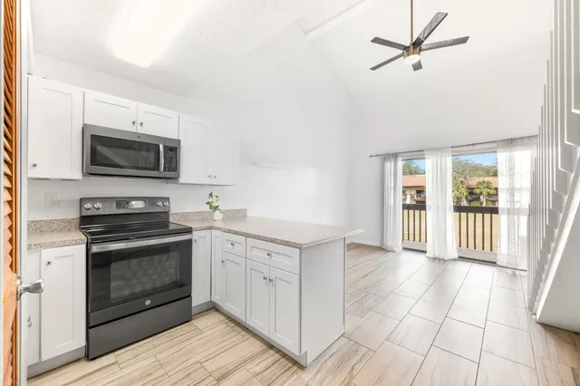 a kitchen with granite countertop a sink a stove and refrigerator