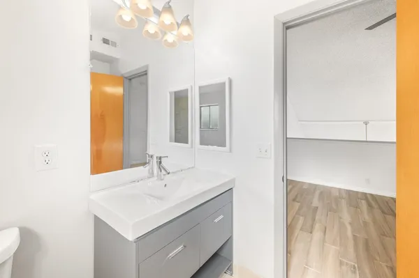 a bathroom with a sink a toilet and a mirror