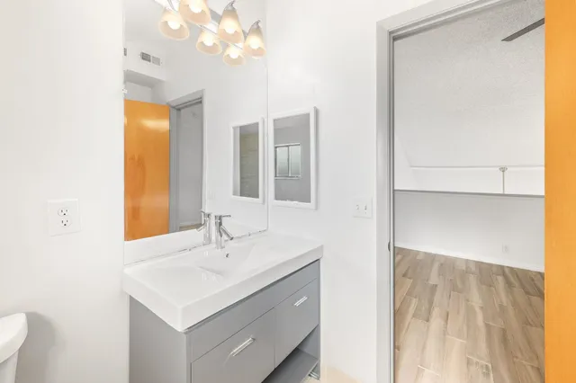 a bathroom with a sink a toilet and a mirror