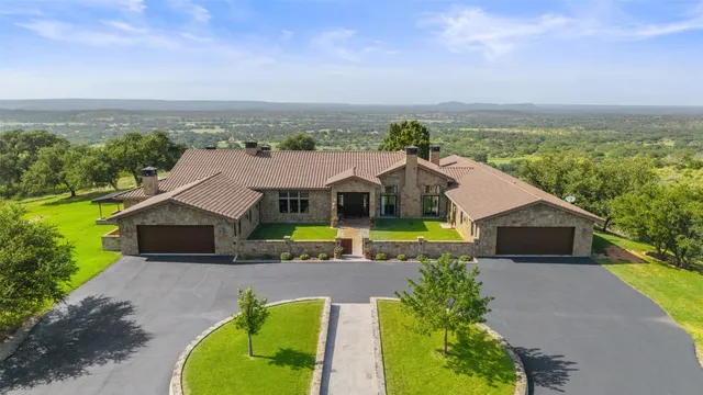 a aerial view of a house with a big yard and large trees