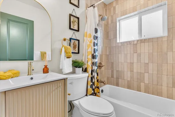 a bathroom with a sink toilet vanity tub and shower