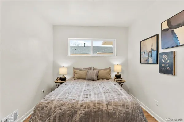 a bedroom with a bed and painting on the wall