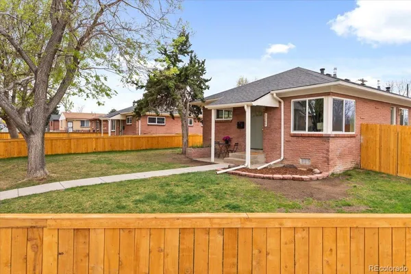 a front view of a house with a yard and trees