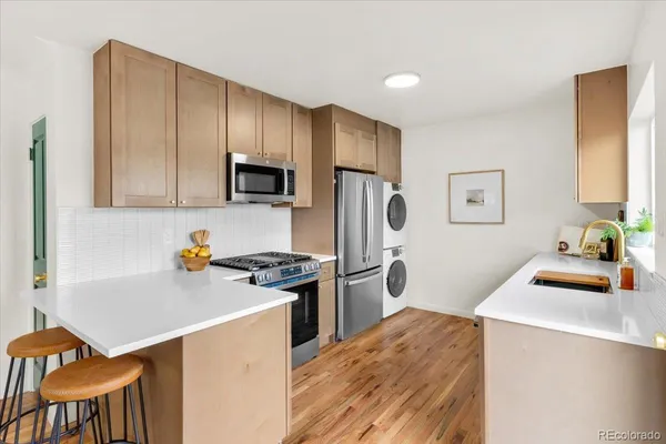 a kitchen with stainless steel appliances a stove refrigerator sink and cabinets