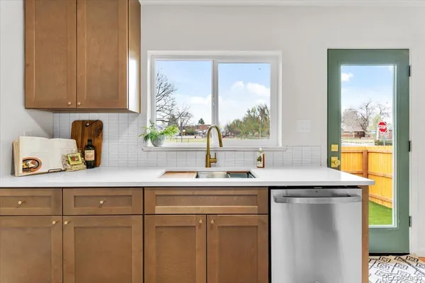 a kitchen with stainless steel appliances granite countertop a sink a window and cabinets
