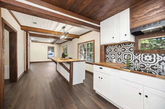 a kitchen with granite countertop white cabinets and wooden floor