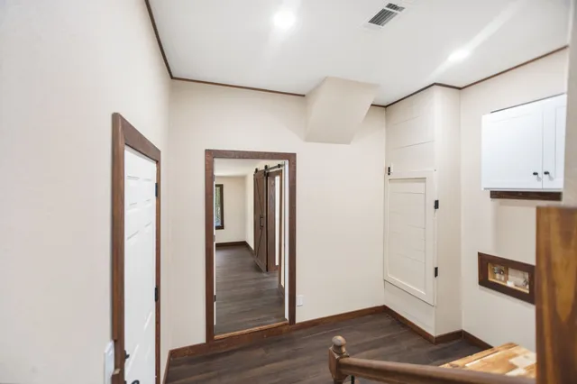 a view of a hallway with wooden floor and closet