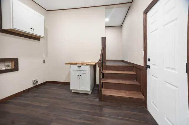 a view of an empty room with wooden floor and stairs