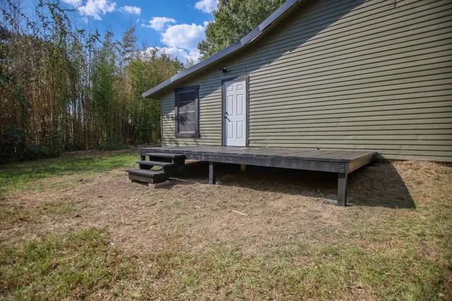 a backyard of a house with wooden floor and fence