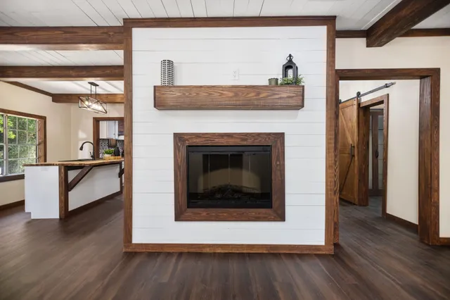 a living room with a fireplace and wooden floor