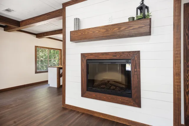 a living room with a fireplace and wooden floor