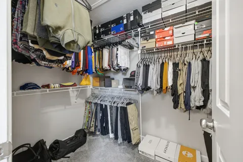 a view of walk in closet with clothes and shoes