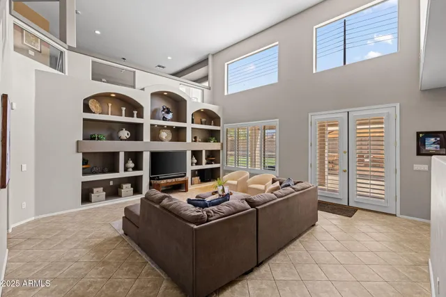 a living room with furniture a flat screen tv and a window