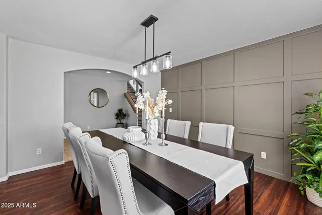 a dining room with furniture a chandelier and wooden floor
