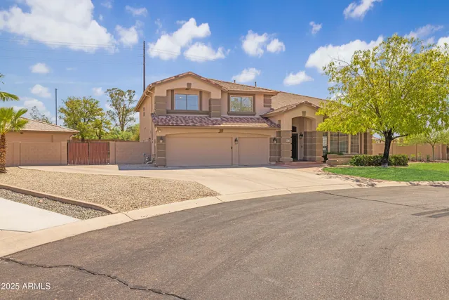a view of a dining room and livingroom with furniture wooden floor a rug a flat screen tv a rug and a chandelier