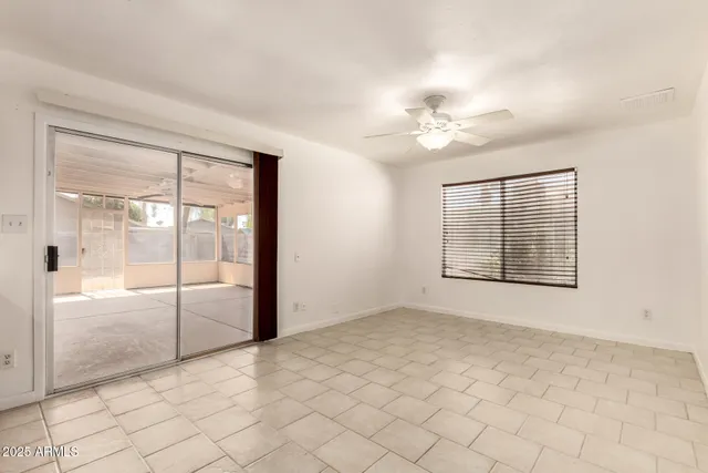 an empty room with windows and fan