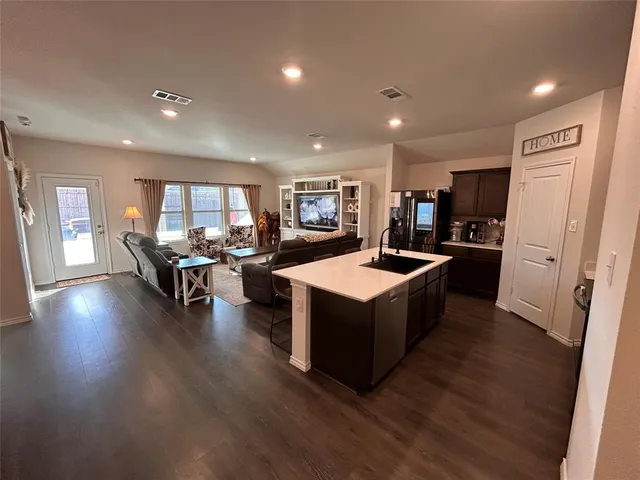 a kitchen with kitchen island a sink appliances and cabinets