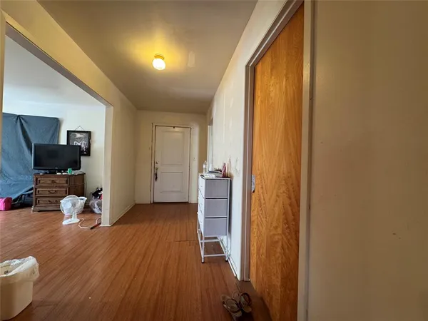 a view of a hallway with wooden floor and furniture