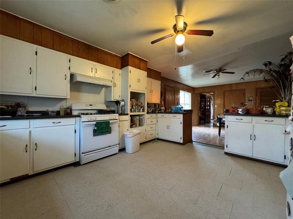 733 Foster Street Marlin, TX 76661 - Photo 2 of 40 a kitchen with cabinets a sink and white appliances