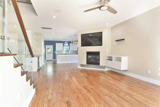a view of empty room with fireplace and wooden floor