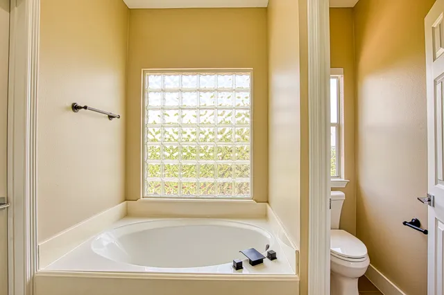 a white bath tub sitting next to a toilet