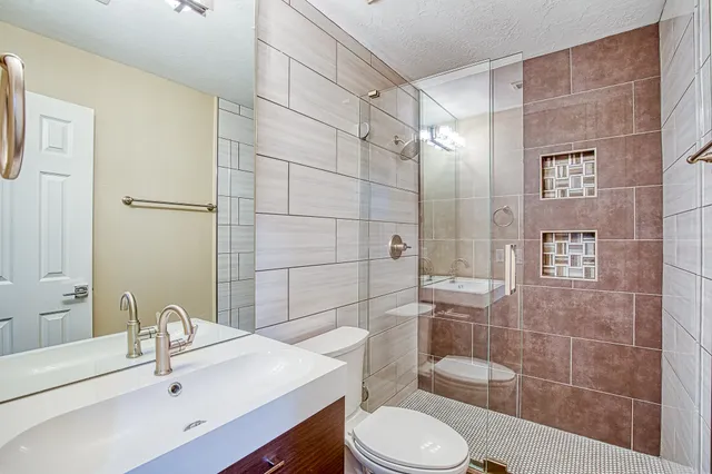a bathroom with a sink toilet and shower