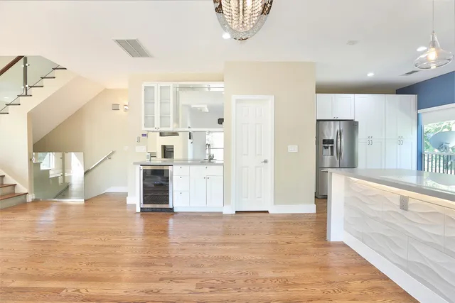 a view of a living room and kitchen with granite countertop wooden floor
