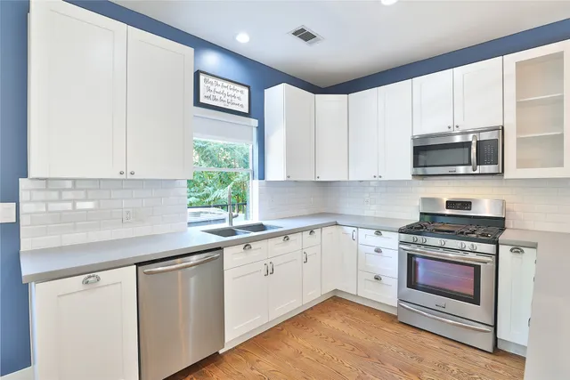 a kitchen with stainless steel appliances granite countertop a stove a sink and a microwave