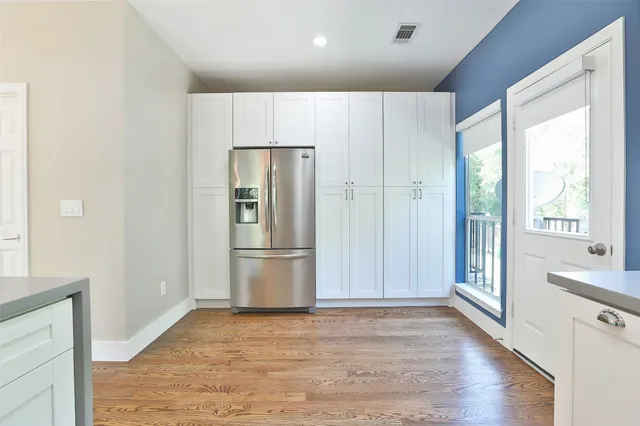 a view of a kitchen with a refrigerator and wooden floor