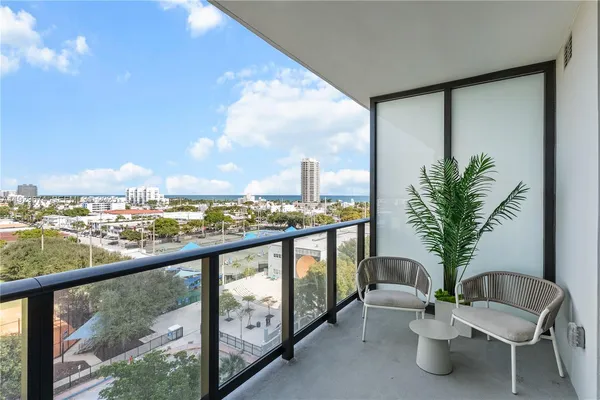 a view of a balcony with furniture and a potted plant