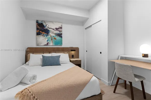 a bedroom with a bed and painting on the wall