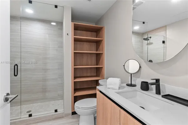 a bathroom with a sink a toilet and shower