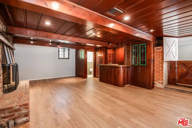 a view of empty room with wooden floor and fireplace