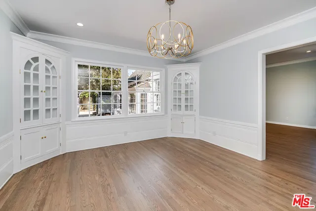 a large white kitchen with granite countertop a refrigerator and a sink