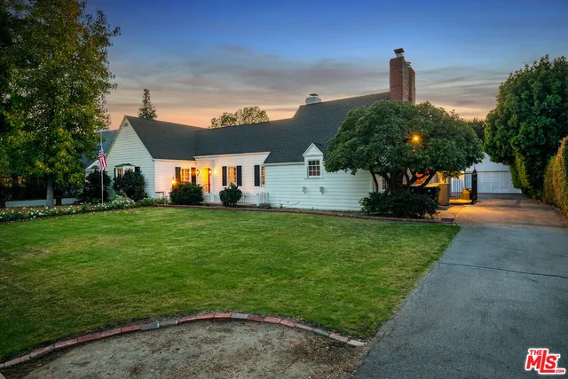 a front view of a house with a garden and yard
