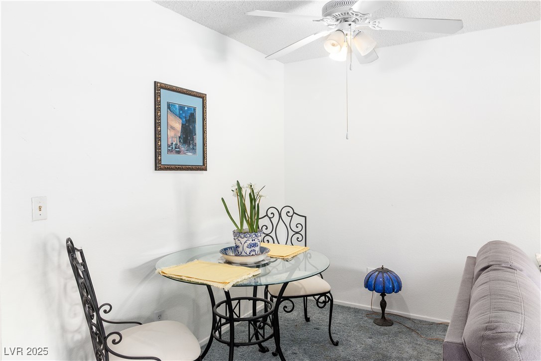 2192 Aspen Mirror Way, Unit 102 Laughlin, NV 89029 - Photo 12 of 58 Carpeted dining area featuring a textured ceiling and ceiling fan