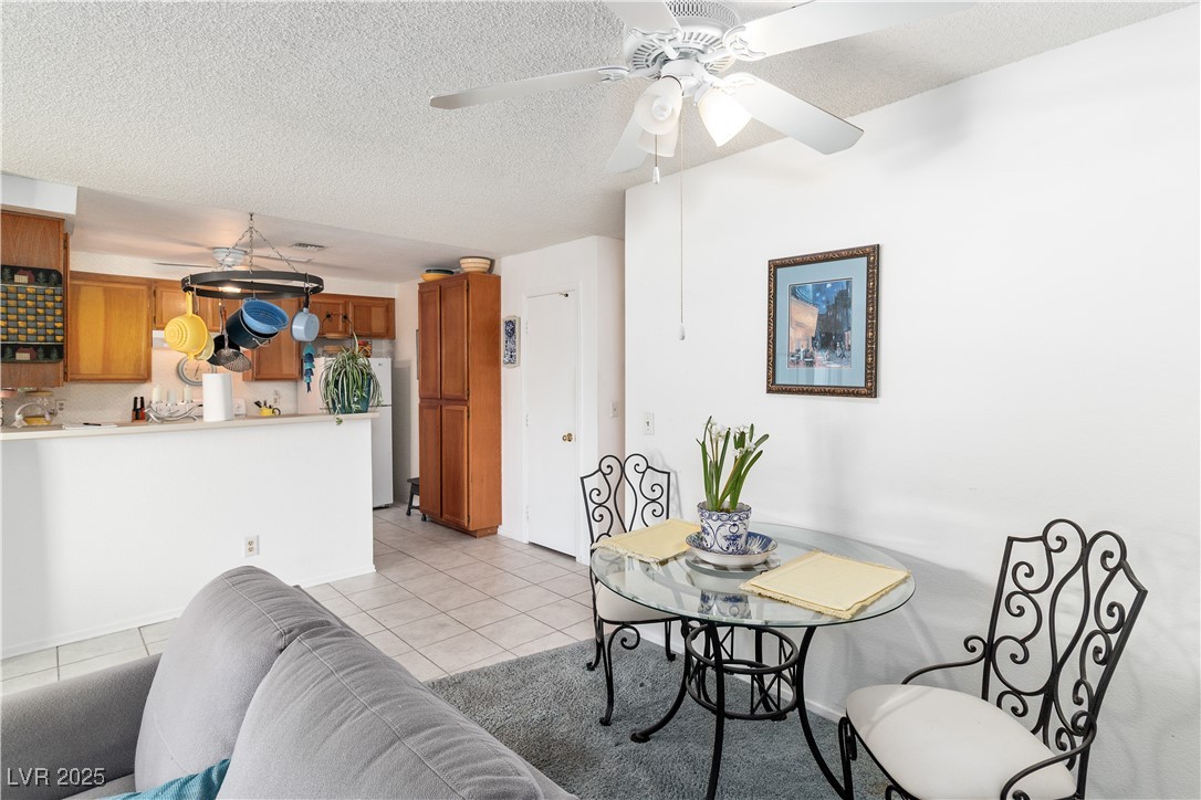 2192 Aspen Mirror Way, Unit 102 Laughlin, NV 89029 - Photo 13 of 58 Dining room featuring light tile patterned flooring, a textured ceiling, and a ceiling fan
