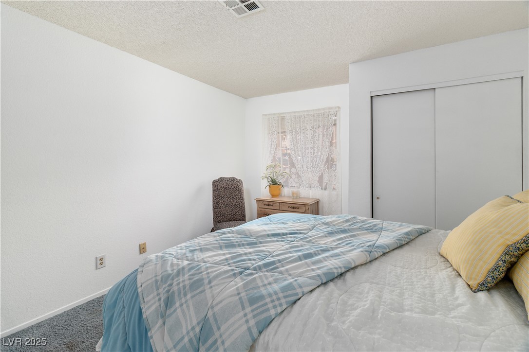 2192 Aspen Mirror Way, Unit 102 Laughlin, NV 89029 - Photo 27 of 58 Carpeted bedroom featuring a textured ceiling and a closet