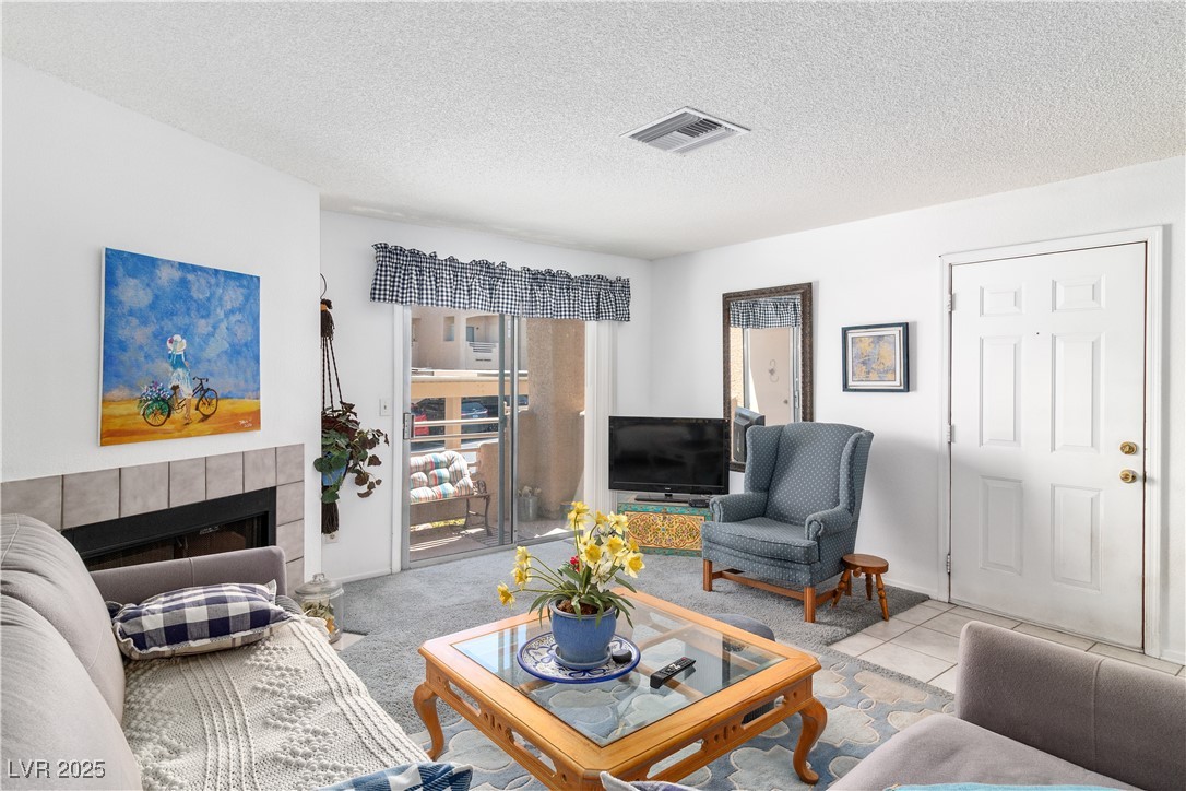 2192 Aspen Mirror Way, Unit 102 Laughlin, NV 89029 - Photo 6 of 58 living area with a textured ceiling, fireplace, and carpet floors