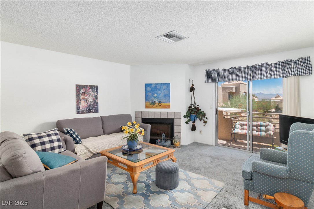 2192 Aspen Mirror Way, Unit 102 Laughlin, NV 89029 - Photo 7 of 58 Carpeted living room featuring a textured ceiling and a tile fireplace