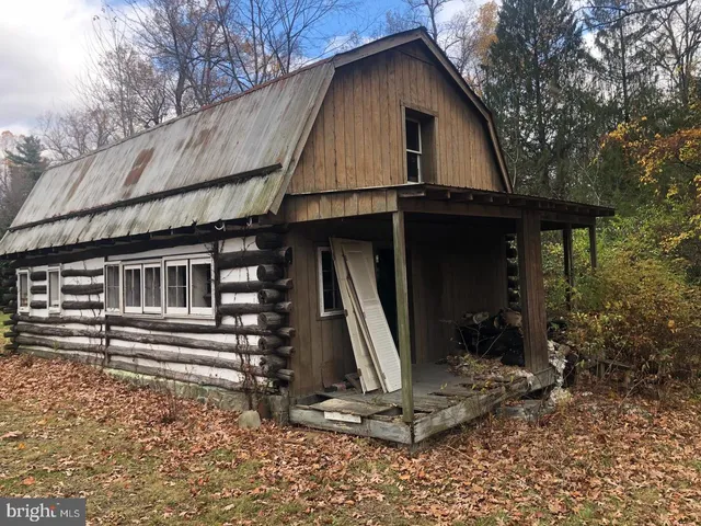 a view of a house with a wooden door next to a yard