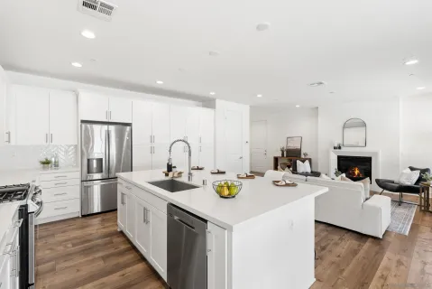 a kitchen with stainless steel appliances a white table chairs and a refrigerator