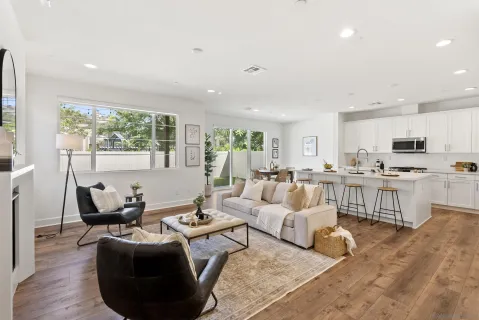 a kitchen with stainless steel appliances kitchen island granite countertop a dining table chairs refrigerator and sink