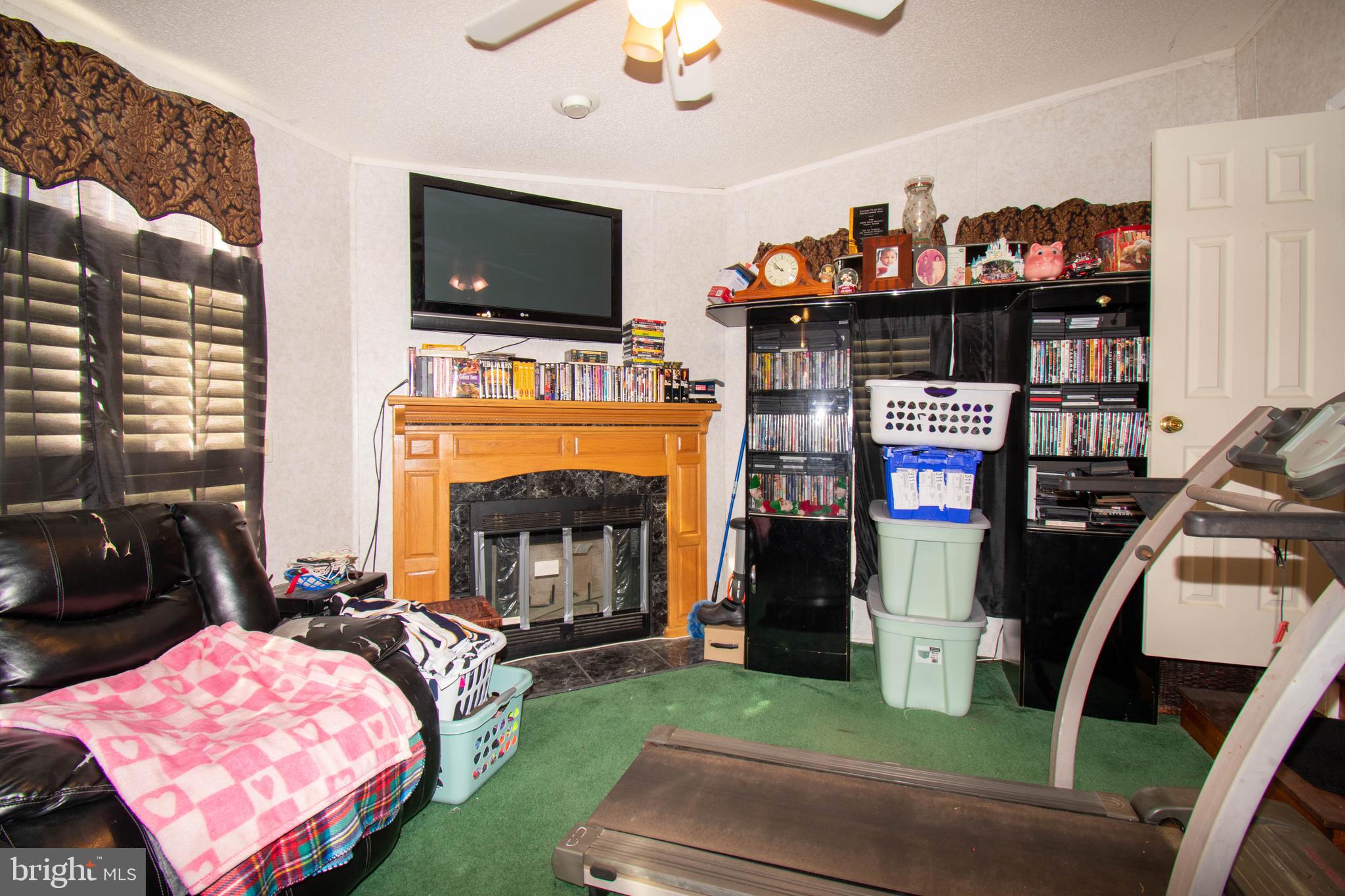8791 Menokin Road Montross, VA 22520 - Photo 24 of 37 a living room with furniture a flat screen tv and a fireplace