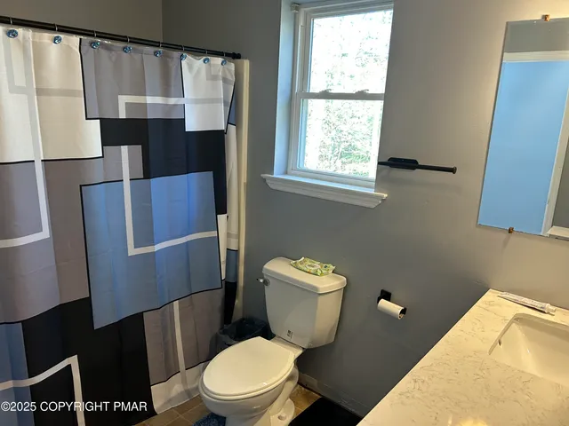a white toilet sitting next to a window