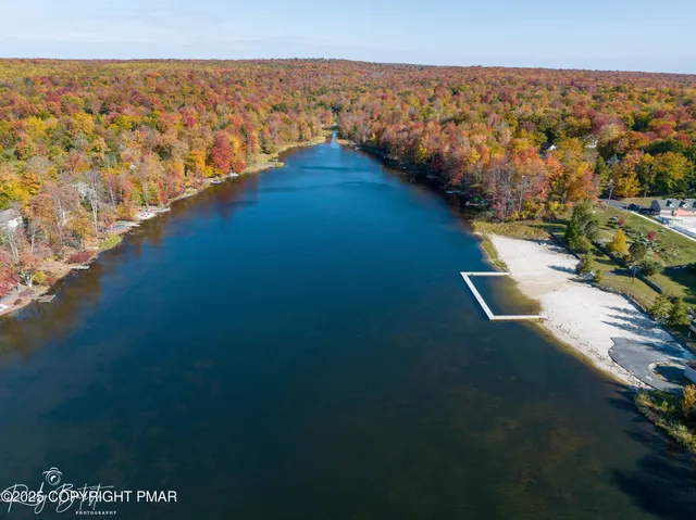 an aerial view of a house with a yard and lake view